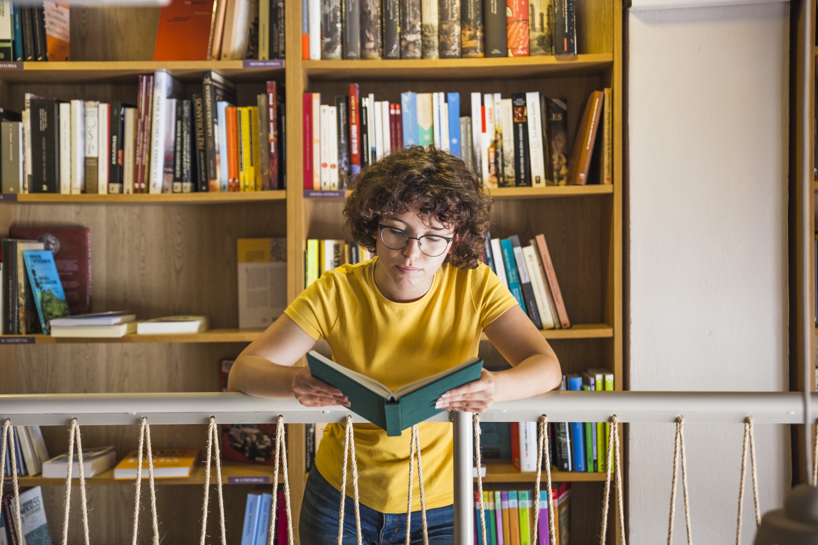 young-thoughtful-woman-reading-book-library